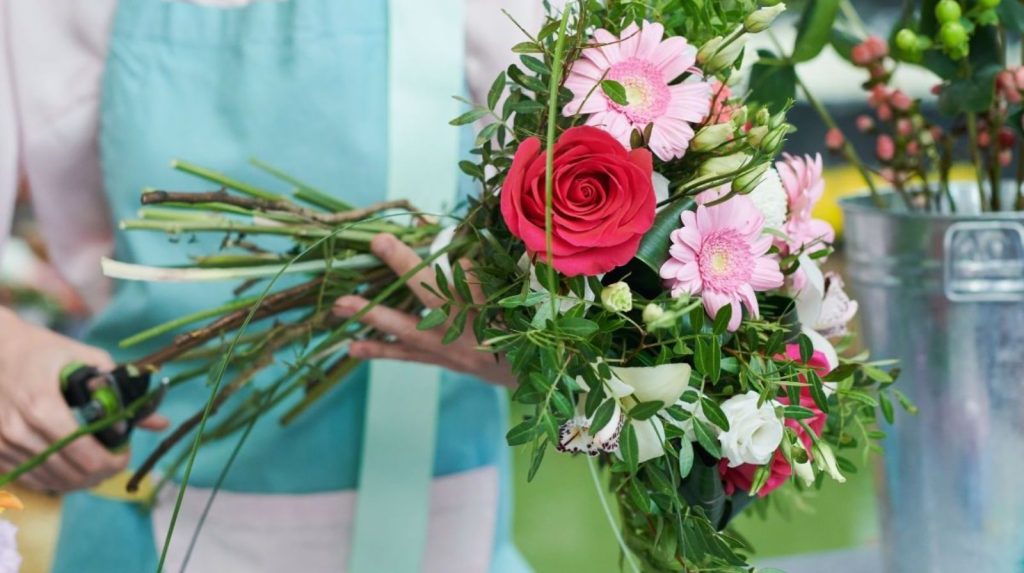 Cortar los tallos adecuadamente Florista cortando los tallos de varias flores de un ramo