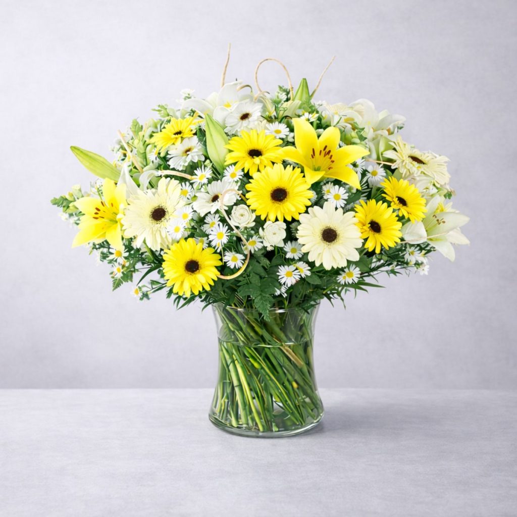 Ramo de flores variado en colores amarillo y blanco colocado en un jarrón