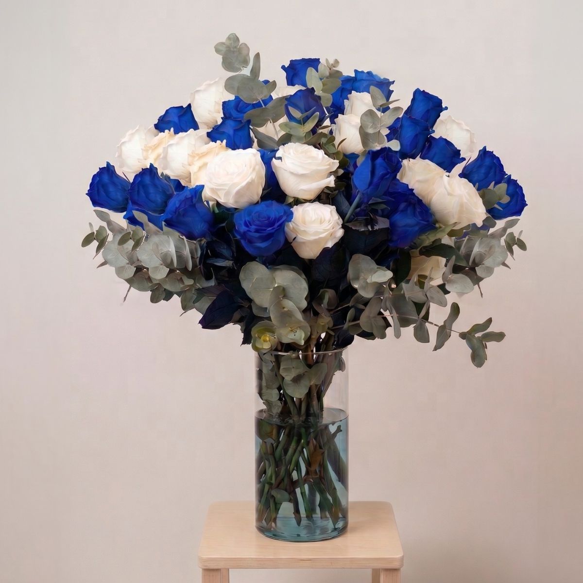 Ramo de rosas azules para cumpleaños Ramo de rosas en color azul y blancas, acompañadas de eucalipto colocadas en un jarrón de cristal para regalar en un cumpleaños