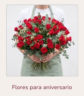 Ramo de rosas rosas rojas de tallo largo sostenido con ambas manos por una persona.