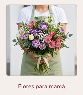 Ramo de flores variado en colores rosa, morado y blanco sostenido por una florista con ambas manos.