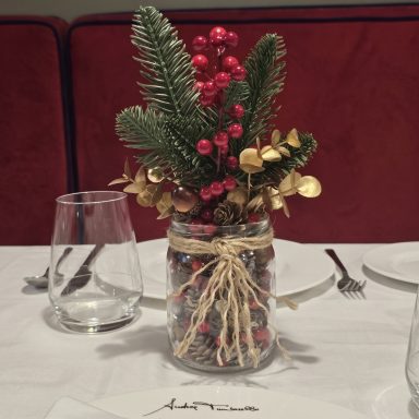 Centros navideños con acebo y piñas para decorar las mesas de un restaurante en Madrid