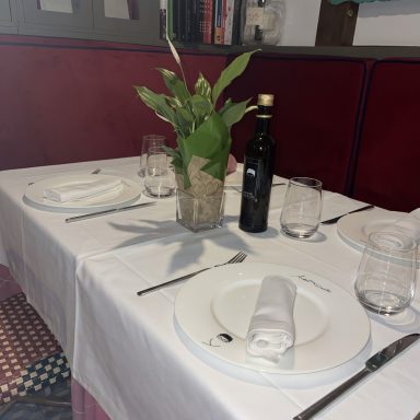 Centro de planta verde en mesa de restaurante, suscripción floral semanal en Madrid