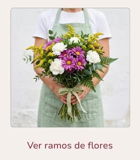 Ramo de flores variadas en tonos blancos, morados y amarillos sostenido con ambas manos