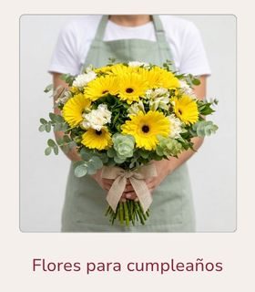Ramo de flores variadas en tonos blancos y amarillos sostenido con ambas manos